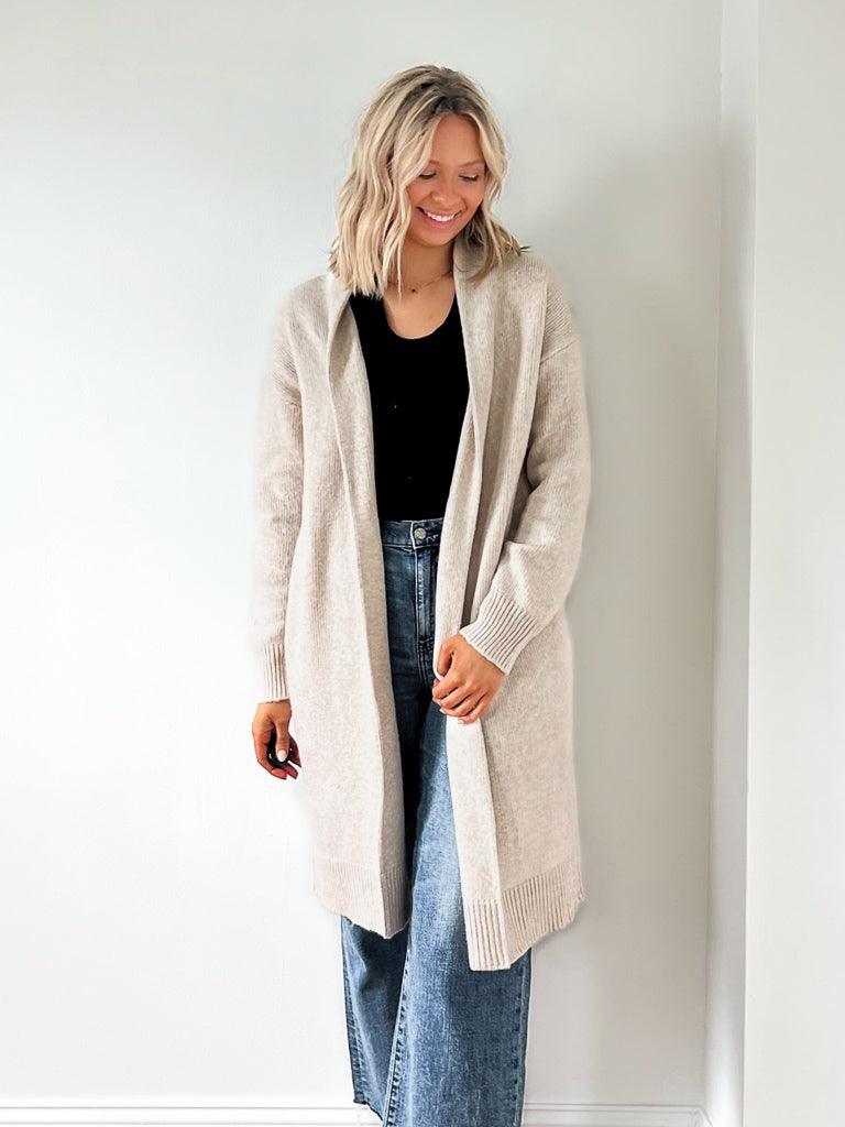 A sweater cardigan with a clean open front and ribbed sleeve details