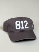 Represent the 812 area code in the charcoal with white stitch hat.